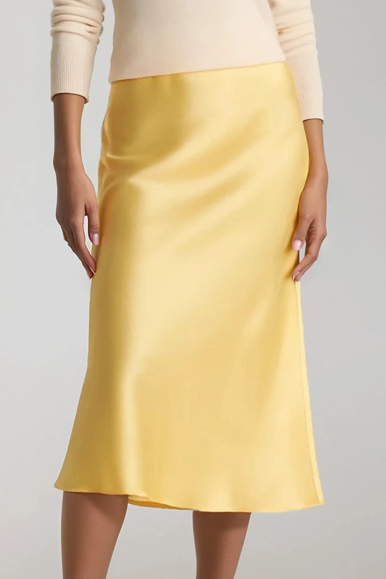Yellow silk skirt worn by a person on a plain background