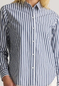 Close-up of a person wearing a blue and white striped organic cotton shirt.