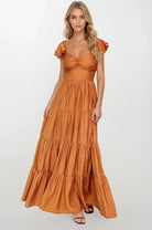 Woman wearing a rust-colored dress with ruffled sleeves on a white background Women's dress, maxi dress, fall dresses