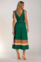 Woman wearing a green dress with a color-blocked skirt on a plain background. Women's dress, women's dresses, fall dress, fall styles, autumn dress, cotton dress