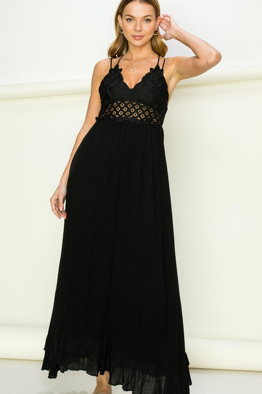 Woman wearing a black lace-trimmed dress against a white background. Women's dress, maxi dress
