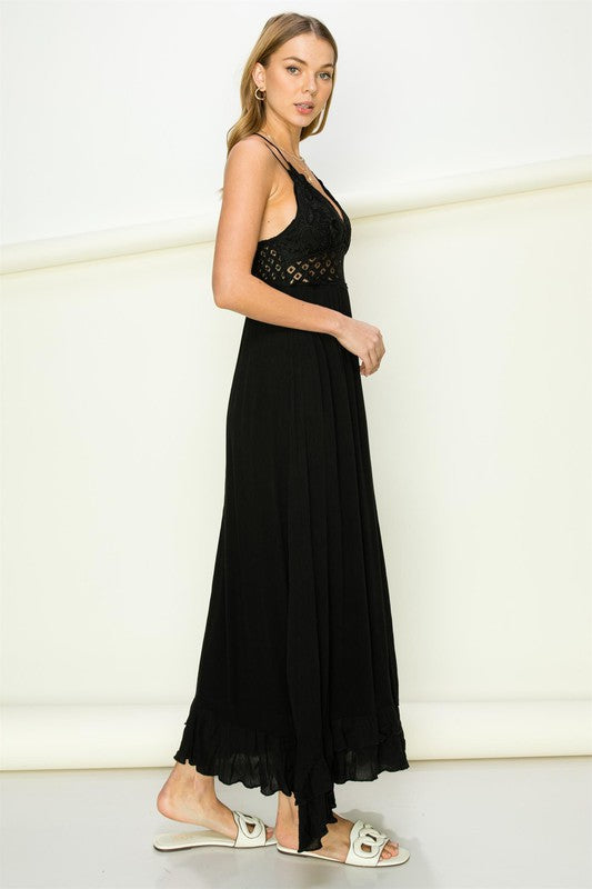 Woman wearing a black dress with lace details on a white background. Women's dress, maxi dress
