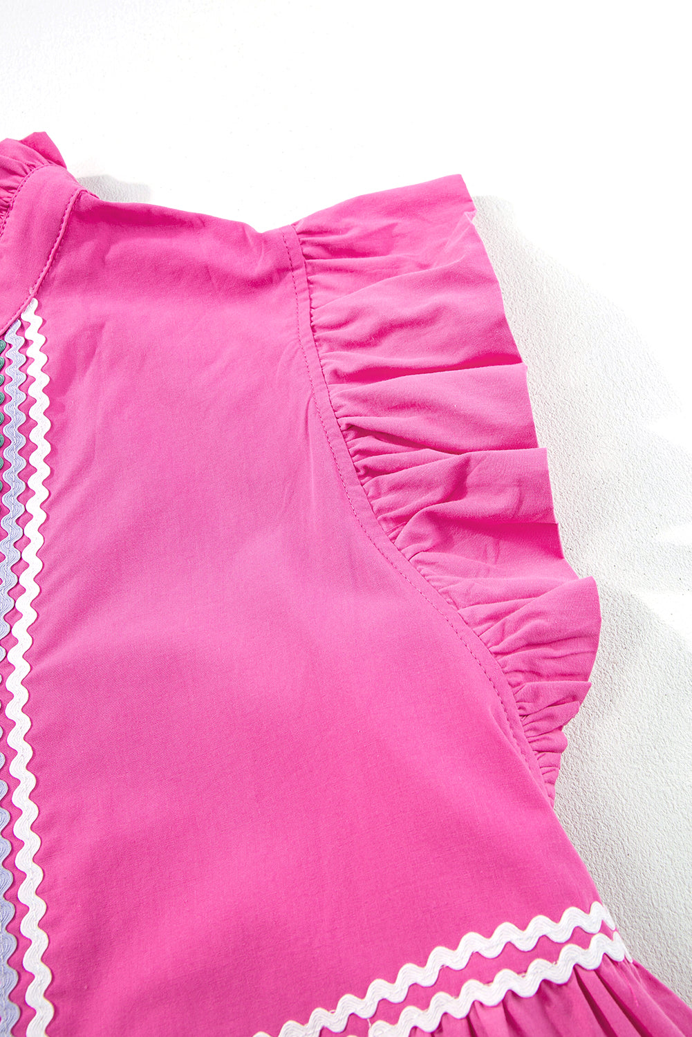 Close-up of a 100% Cotton Bright Pink Tiered Mini Dress with Ric Rac Trim on a white background. Women's dress, 100% cotton, cotton dress, summer dress, mini dress.