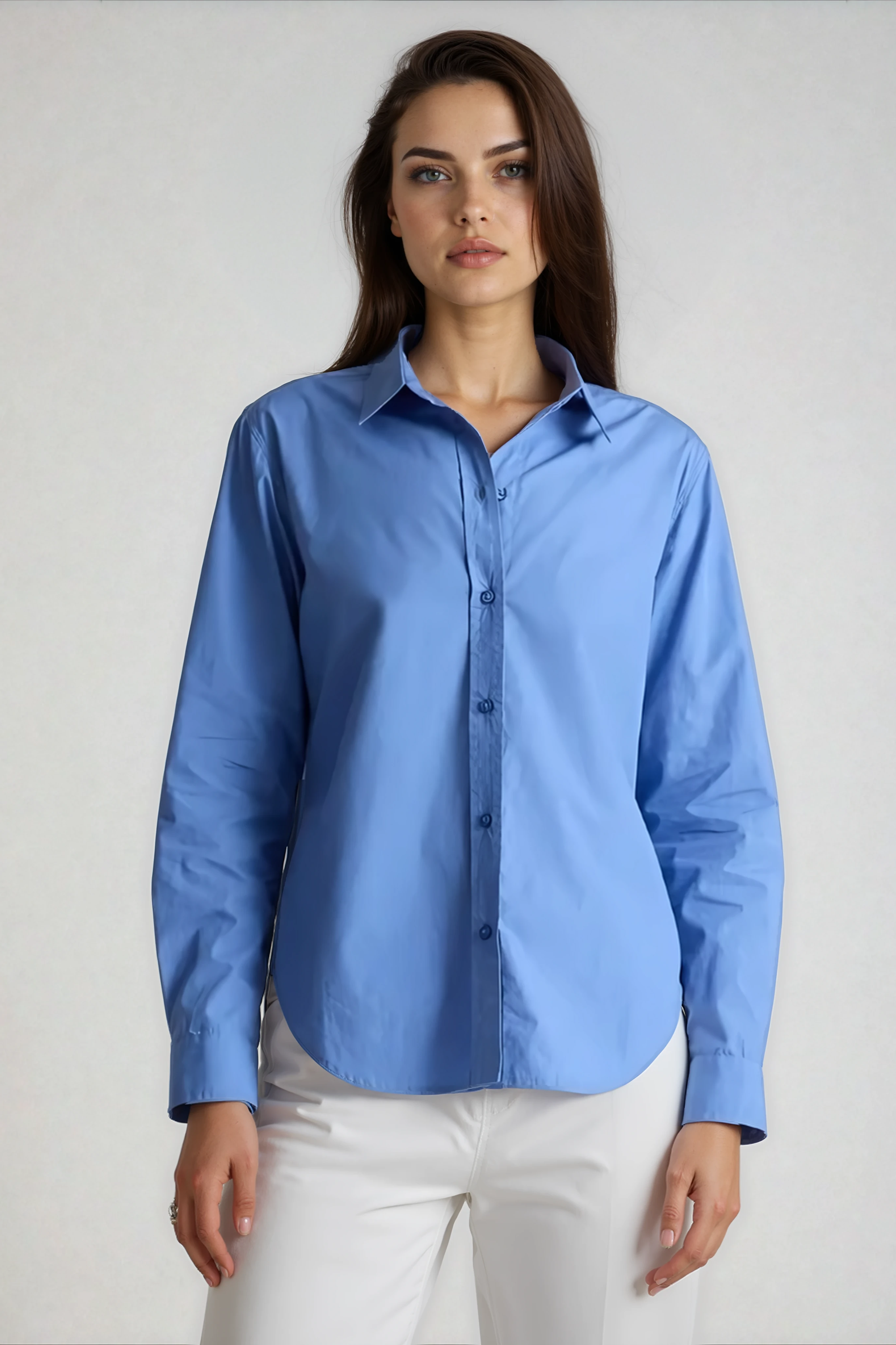 Woman wearing a blue shirt and white pants on a plain background