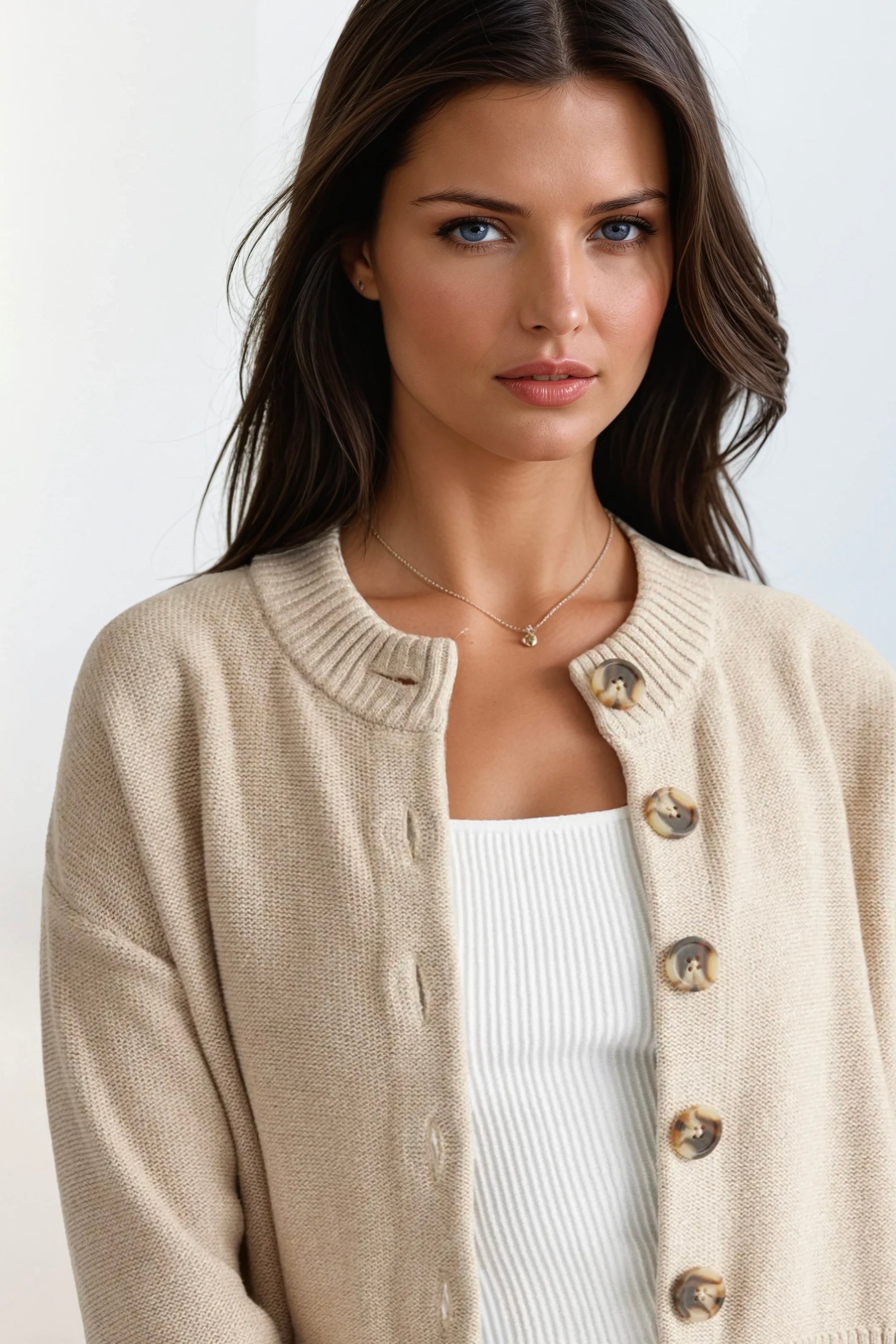 Woman wearing a beige cardigan on a white background