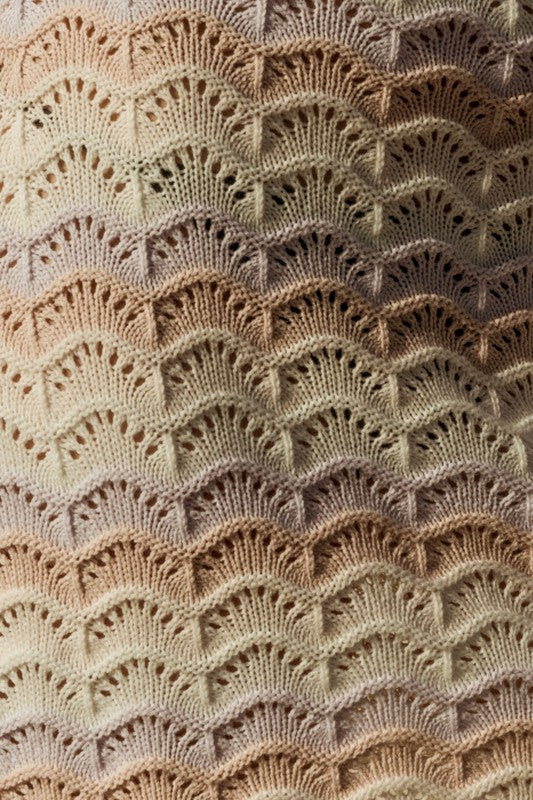 Close-up of a textured fabric with a scalloped pattern in beige and brown tones.