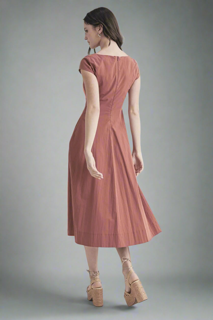 Woman wearing a pink dress on a gray background