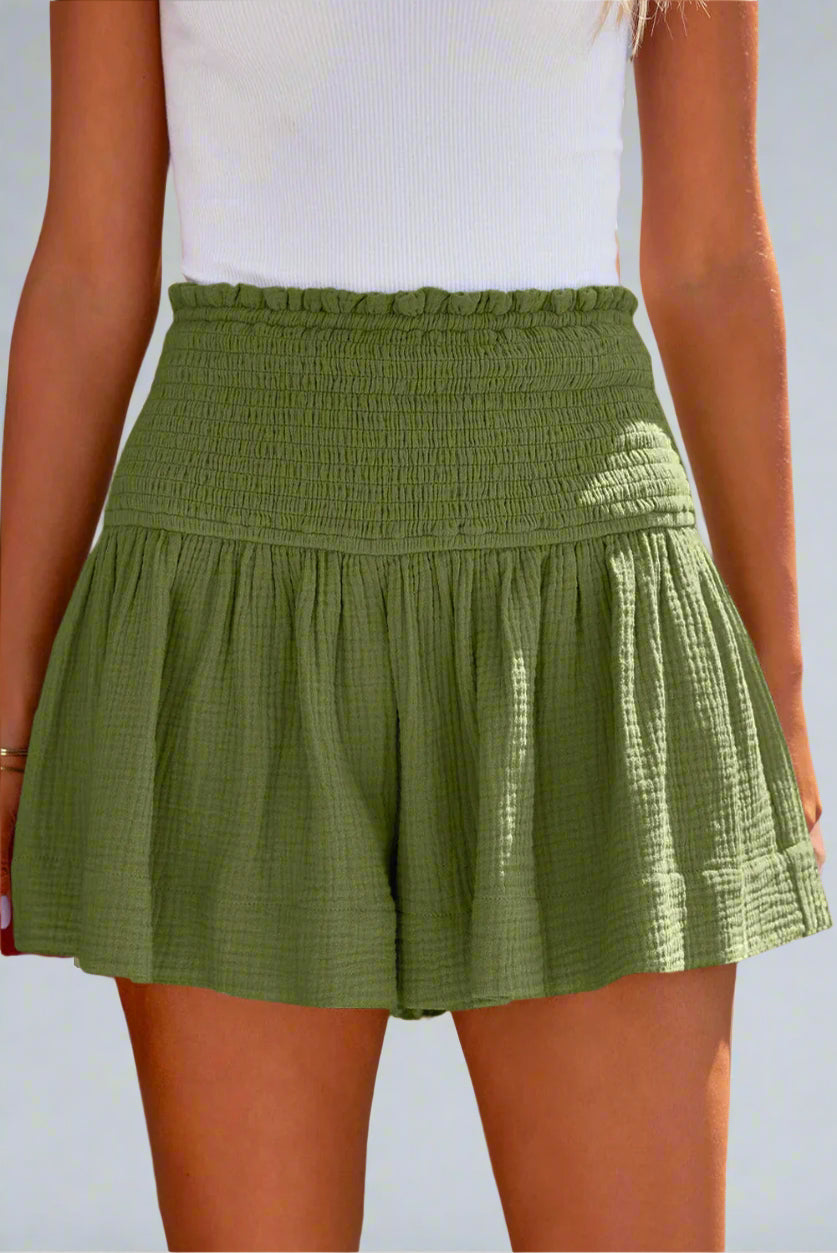 100% Cotton Green Moss Smocked Shorts worn by a model on a plain background