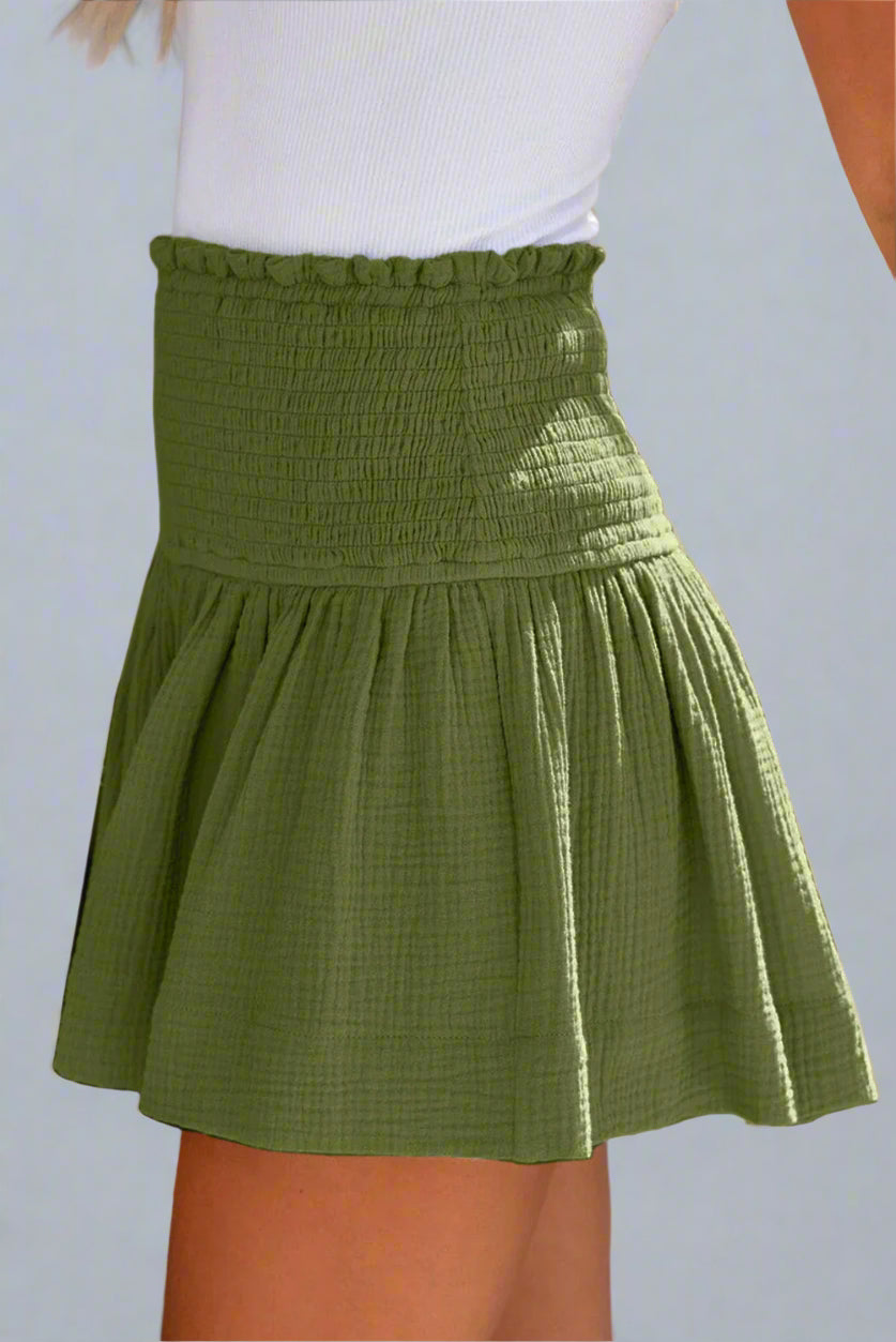 100% Cotton Green Moss Smocked Shorts  being worn by model on a plain background